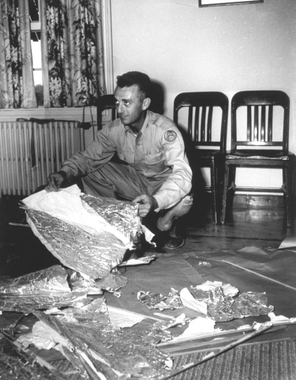 Jesse Marcel montrant dans le bureau de Ramey les débris
      de ballon comme étant ceux récupérés sur le site du crash de Roswell